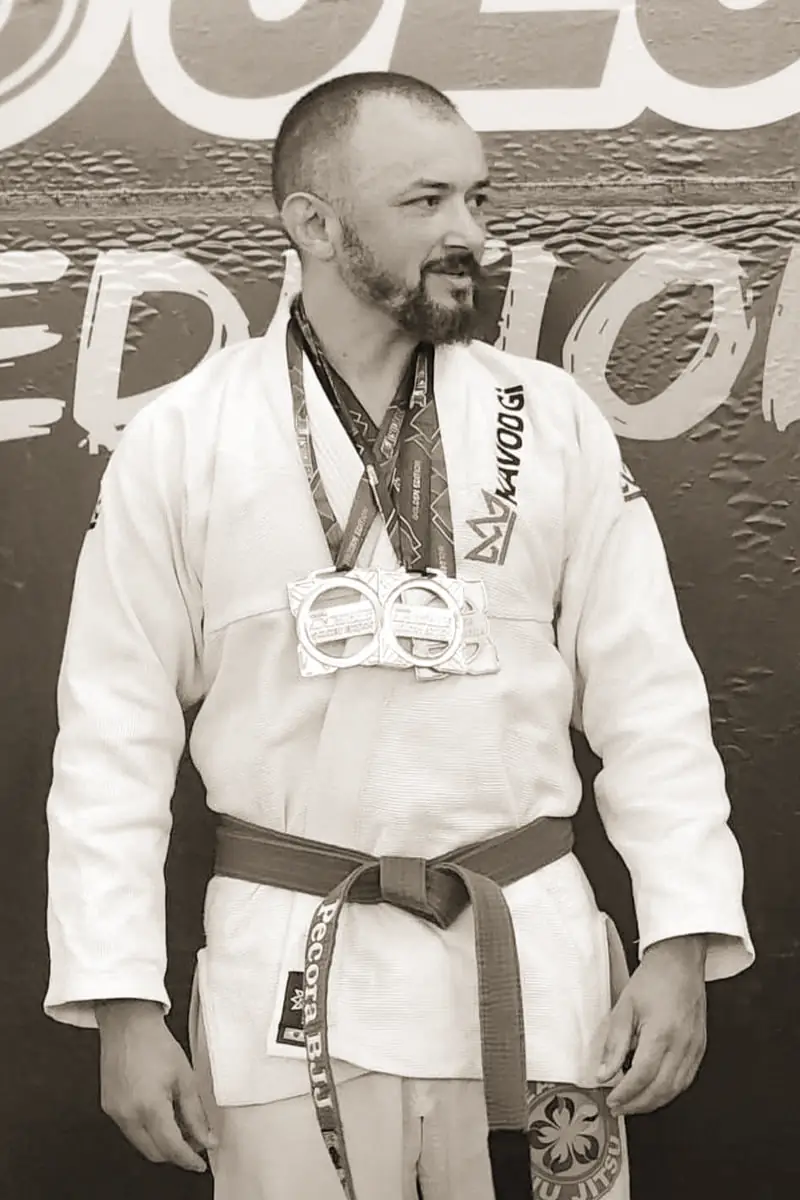 Pécora de kimono branco com medalhas no peito, na premiação
